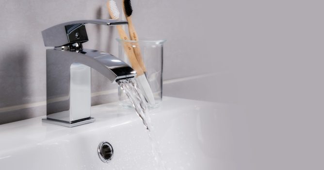 closeup-shot-water-flowing-from-basin-mixer-tap-bathroom