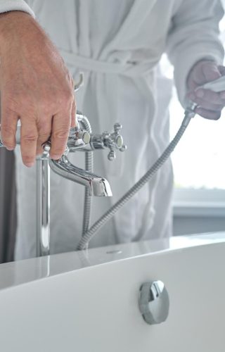 man-white-terry-bathrobe-filling-bathtub-with-water